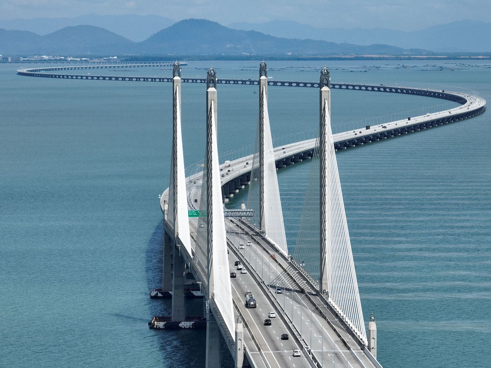 Aerial view of the Penang Bridge cable-stayed span over the channel, a daily crossing for Penang JPJ speed limiter fleets