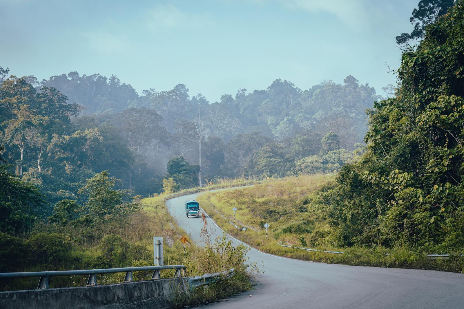 Winding two-lane road through forested hills