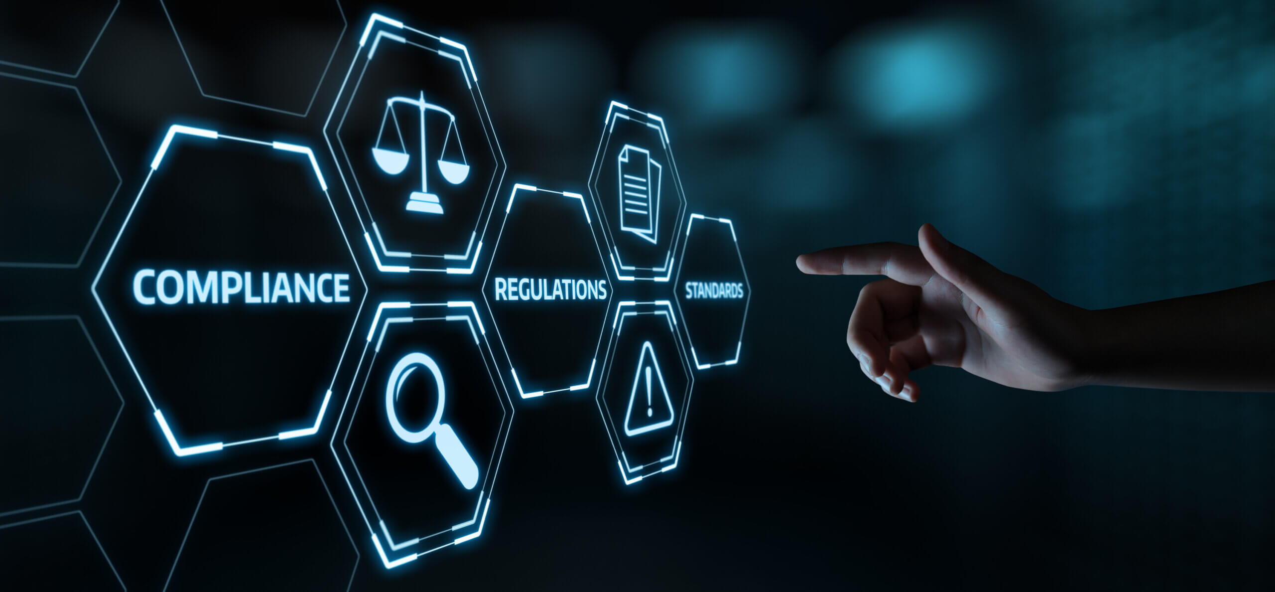 Hand pointing at a digital graphic of compliance, regulations and standards icons
