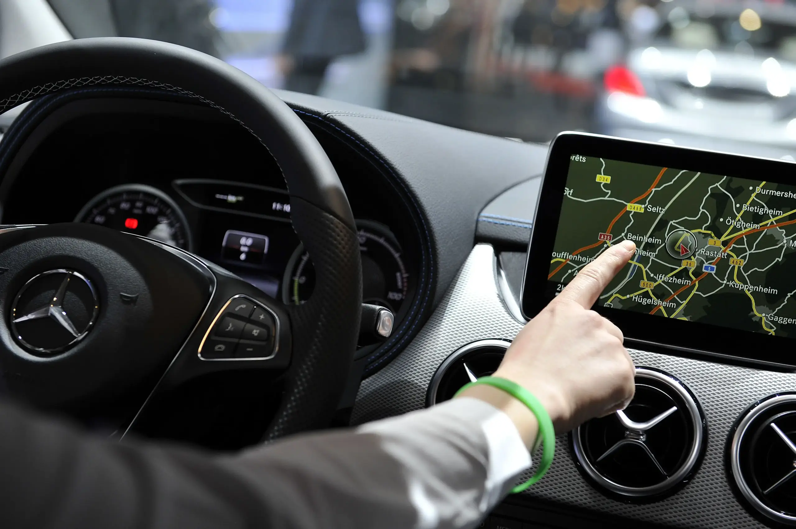 Driver touching a car's dashboard navigation screen