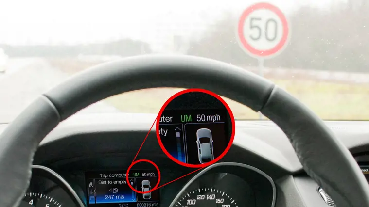 Driver's view of a 50 speed limit sign, with the dashboard showing a 50 mph speed limiter setting