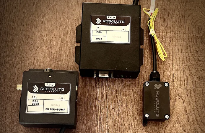 Resolute Dynamics FSL fuel-type speed limiter kit: ECU, filter pump unit and sensor on a wooden table